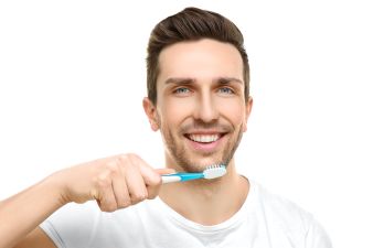 Young handsome man brushing teeth
