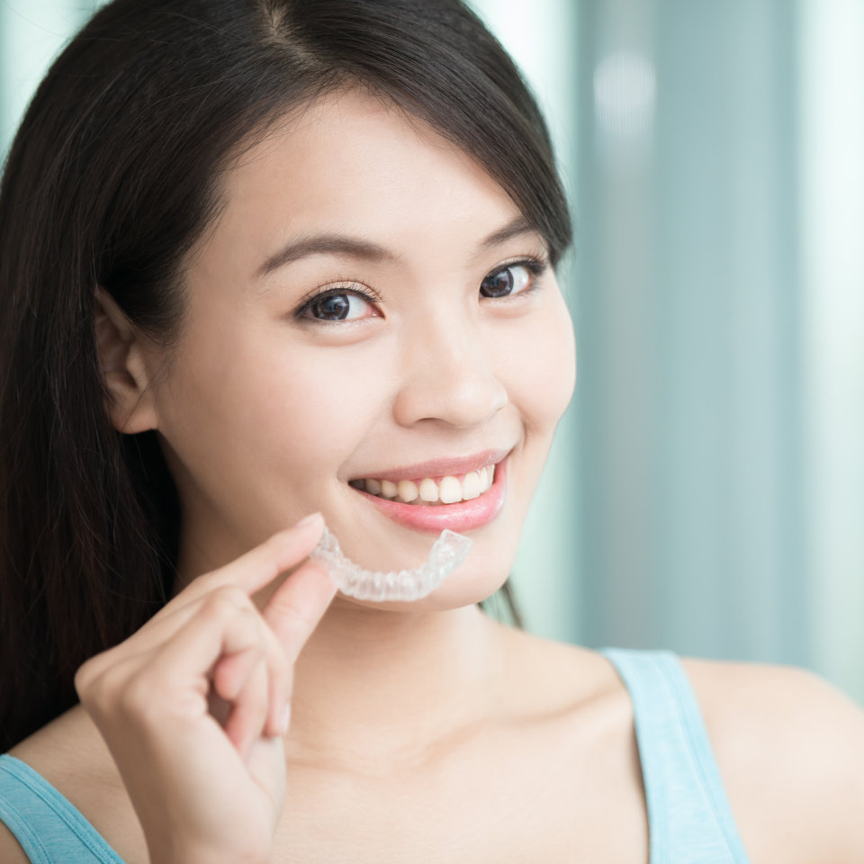 pretty asian woman holding smilefx