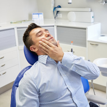 a man with a toothache in a dental chair