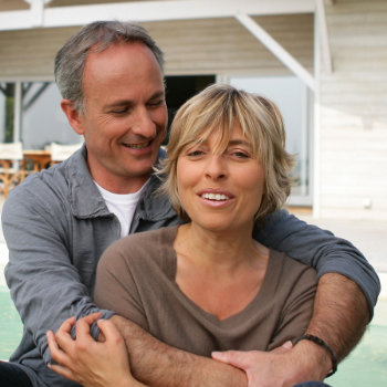 mature Couple sitting in front of the house