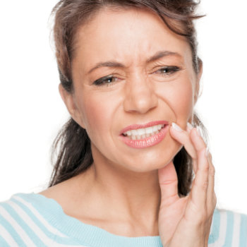 mature woman with pain holds her cheek