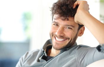 portrait of a happy middle-aged man with a perfect smile sitting on a sofa