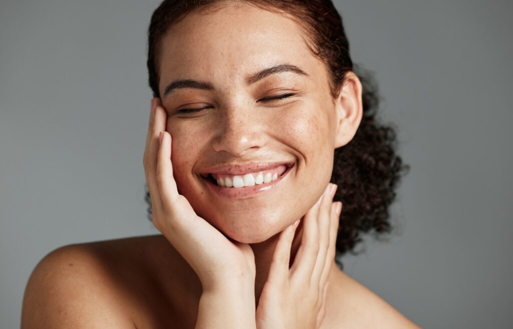 Face, beauty and satisfaction with a model black woman in studio on a gray background to promote natural skincare. Facial, wellness and makeup with an attractive young female happy with cosmetics