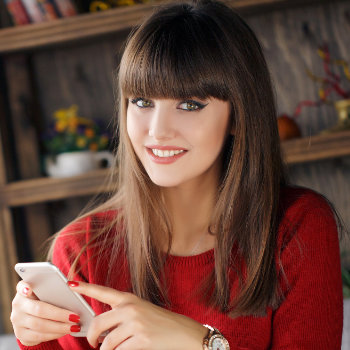 Girl reading SMS on mobile phone Roswell Complete Dentistry care
