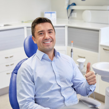 Satisfied man thumbs up in dentist chair Roswell Complete Dentistry
